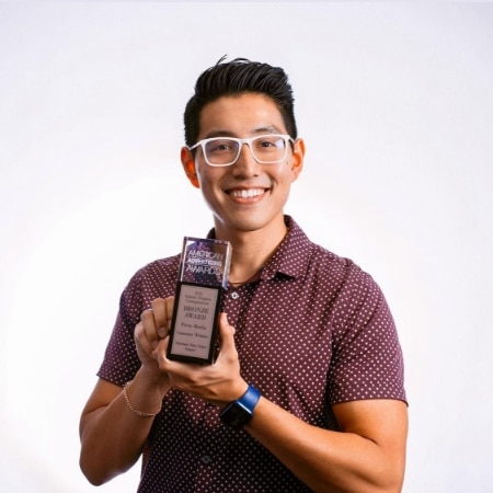 Justin Huynh holding an award